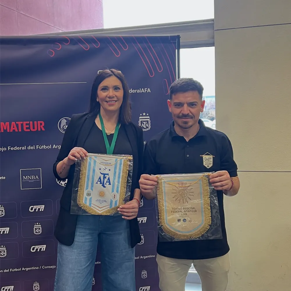 Mauro Guerrero, fundador de StandArte, con el banderín oficial del lanzamiento del Torneo Federal Regional Amateur 2026, junto al banderín de AFA, frente al panel del Consejo Federal